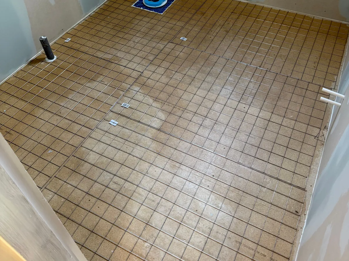 Golvvärme installerad i badrum inför beläggning